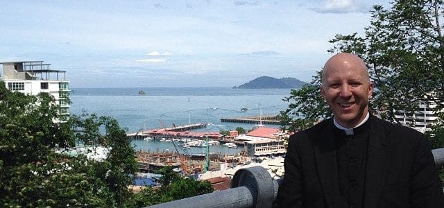 Fr. Boquet in Kota Kinabalu, Malaysia at an observation point overlooking downtown and the China Sea.