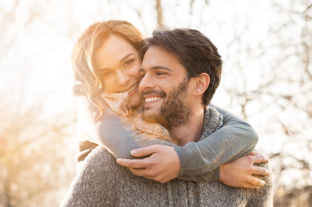 happy couple outdoors piggyback