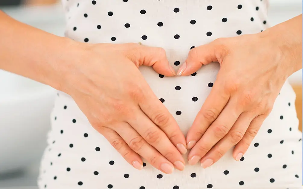 mom with hands making heart pregnant