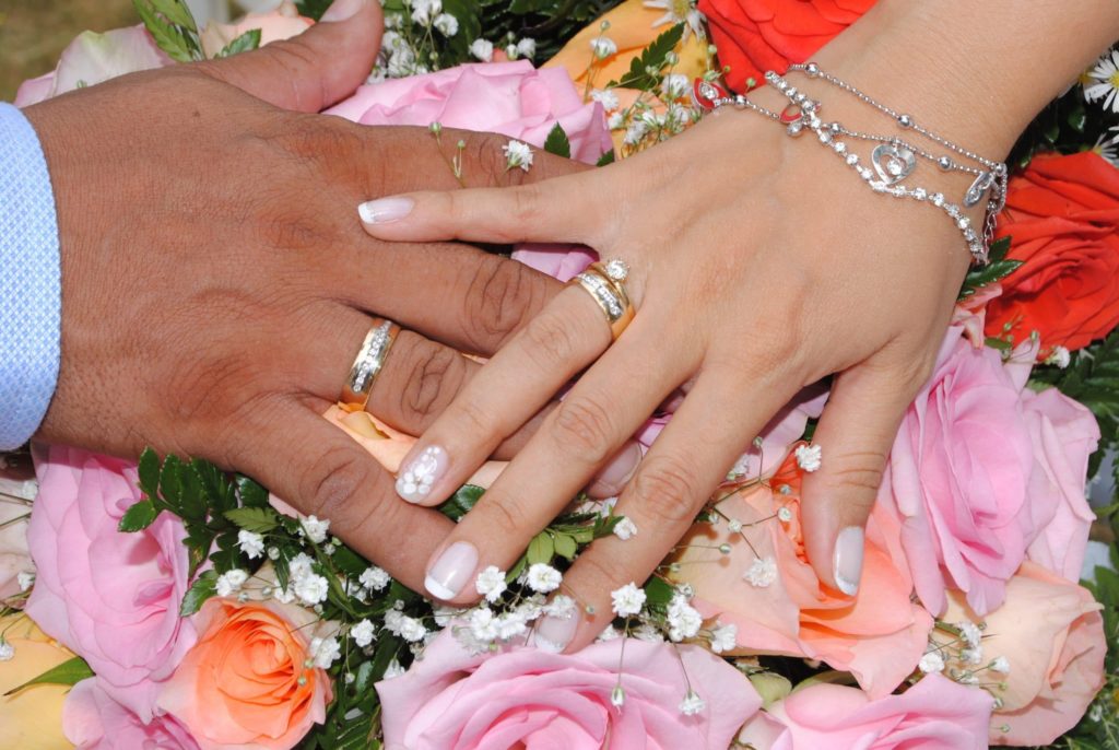hands of a newly married couple wearing wedding rings