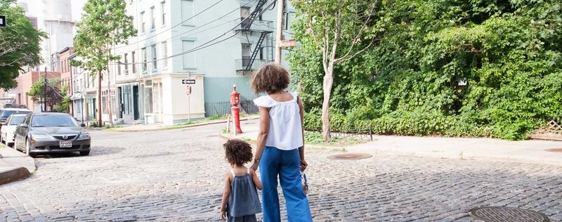 single mom and daughter walking on street
