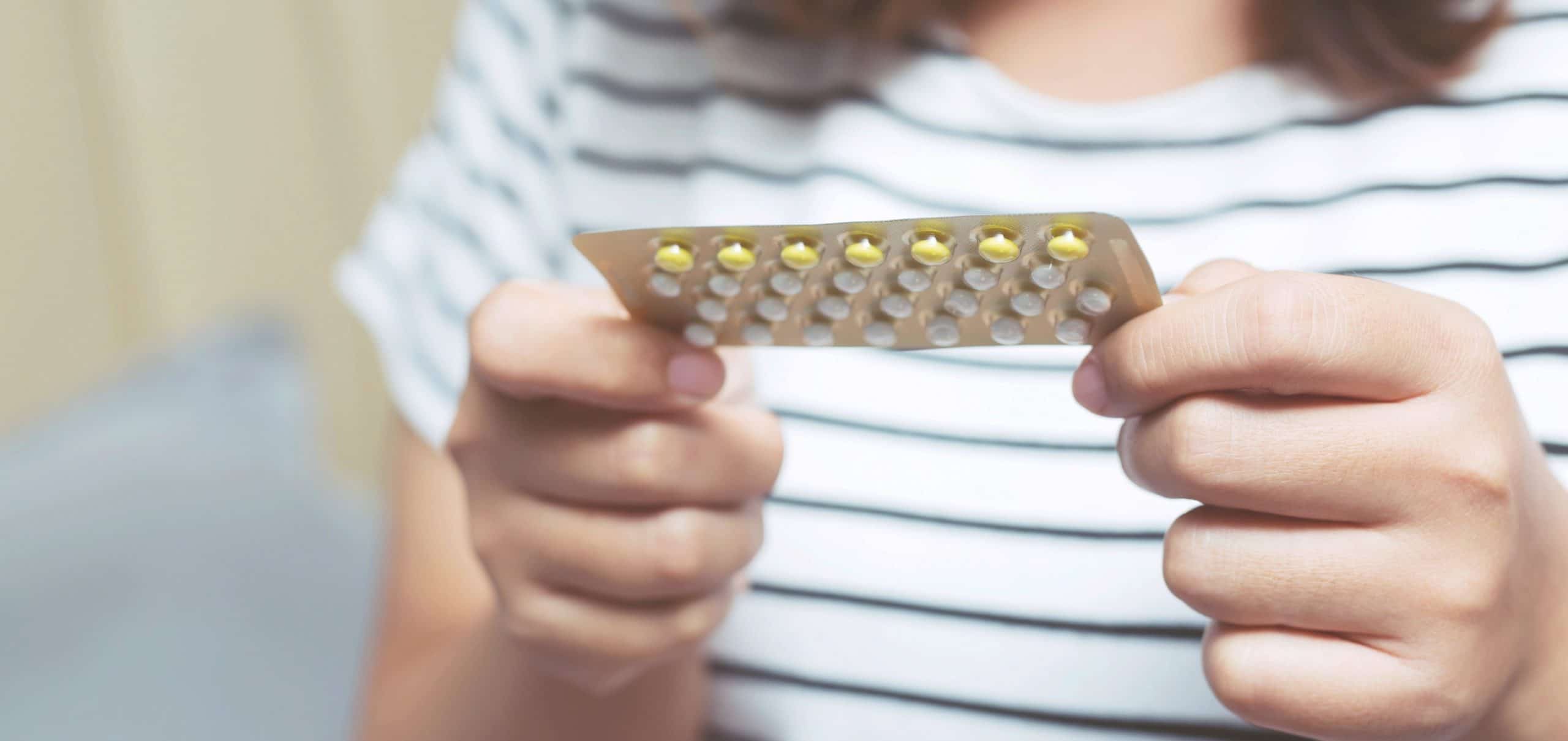 woman holding packet of birth control pills