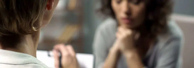 Young depressed woman talking to lady psychologist during session, mental health