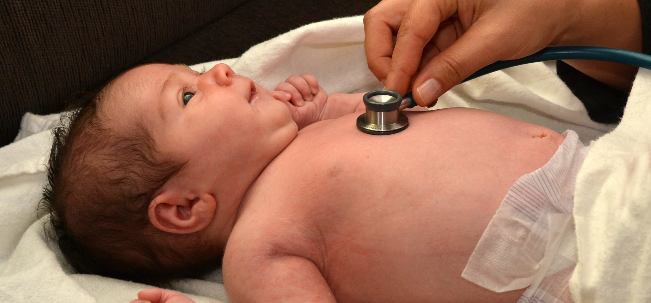 Midwife checks newborn baby heartbeat