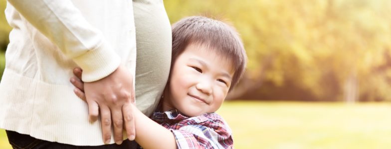 big brother hugging pregnant mom