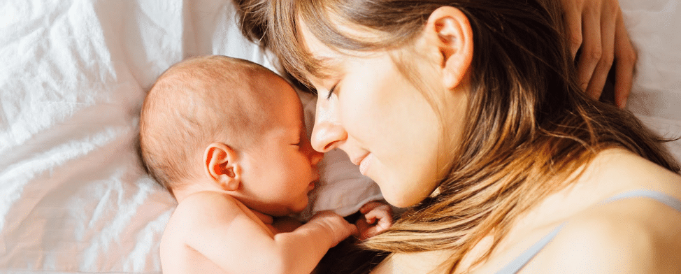 a mother with her infant lying in bed