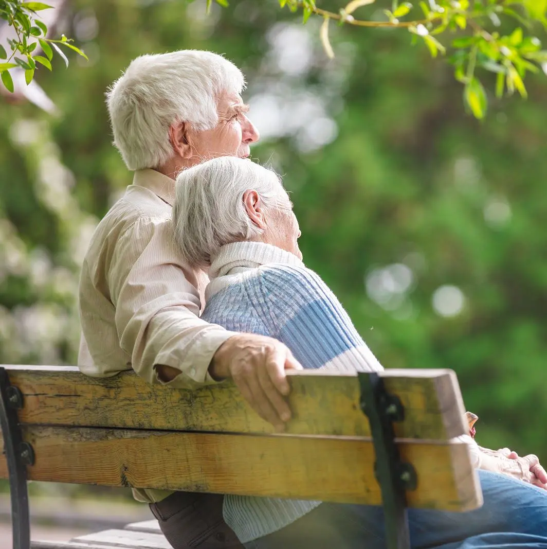 elderly couple happy on bench