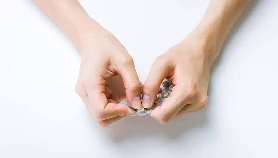 woman taking pill from packet