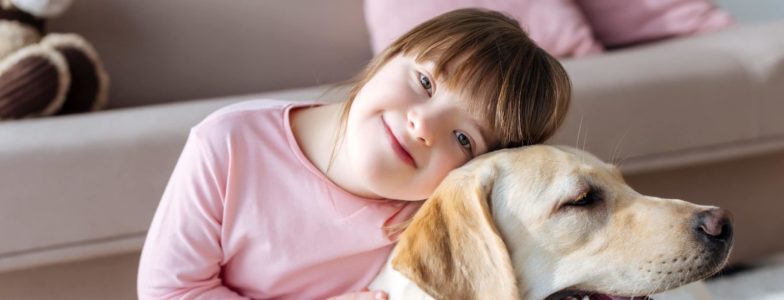 Child with down syndrome cuddling with dog