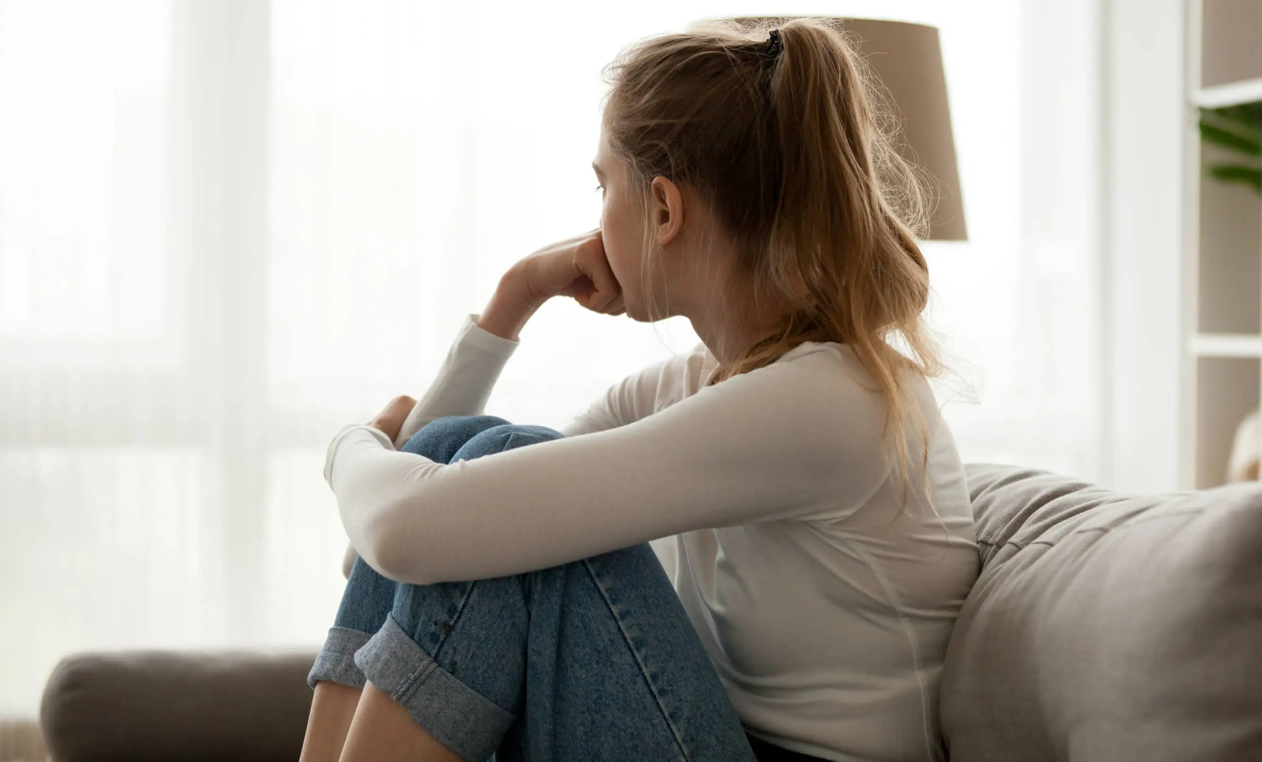 woman sad pensive looking out window