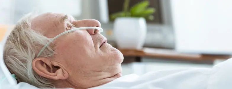 side view of senior man in coma on bed in hospital