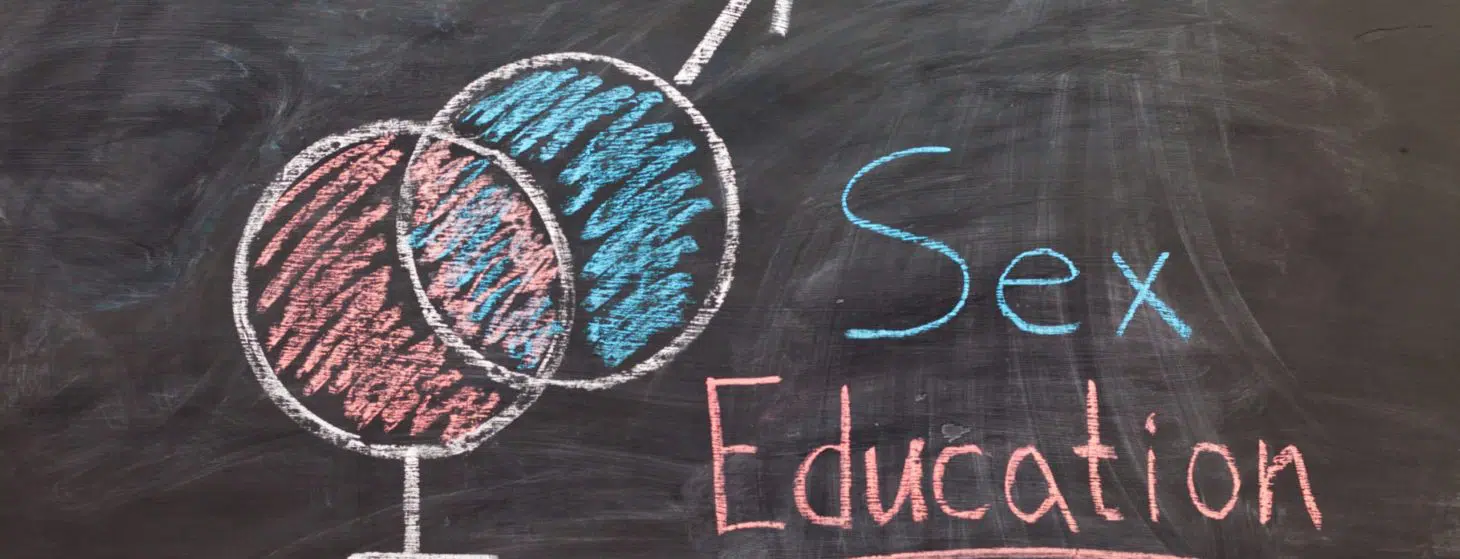 Sex Education. Male and female sex symbol on black chalkboard. Woman draws gender symbols