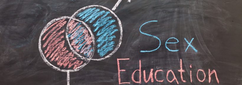 Sex Education. Male and female sex symbol on black chalkboard. Woman draws gender symbols