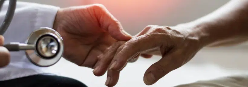 Geriatric doctor or geriatrician concept. Doctor physician hand on happy elderly senior patient to comfort in hospital examination room or hospice nursing home or wellbeing county.
