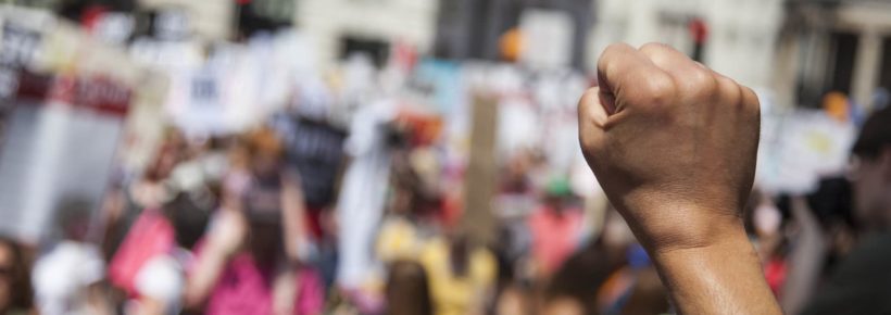 A raised fist of a protestor at a political demonstration