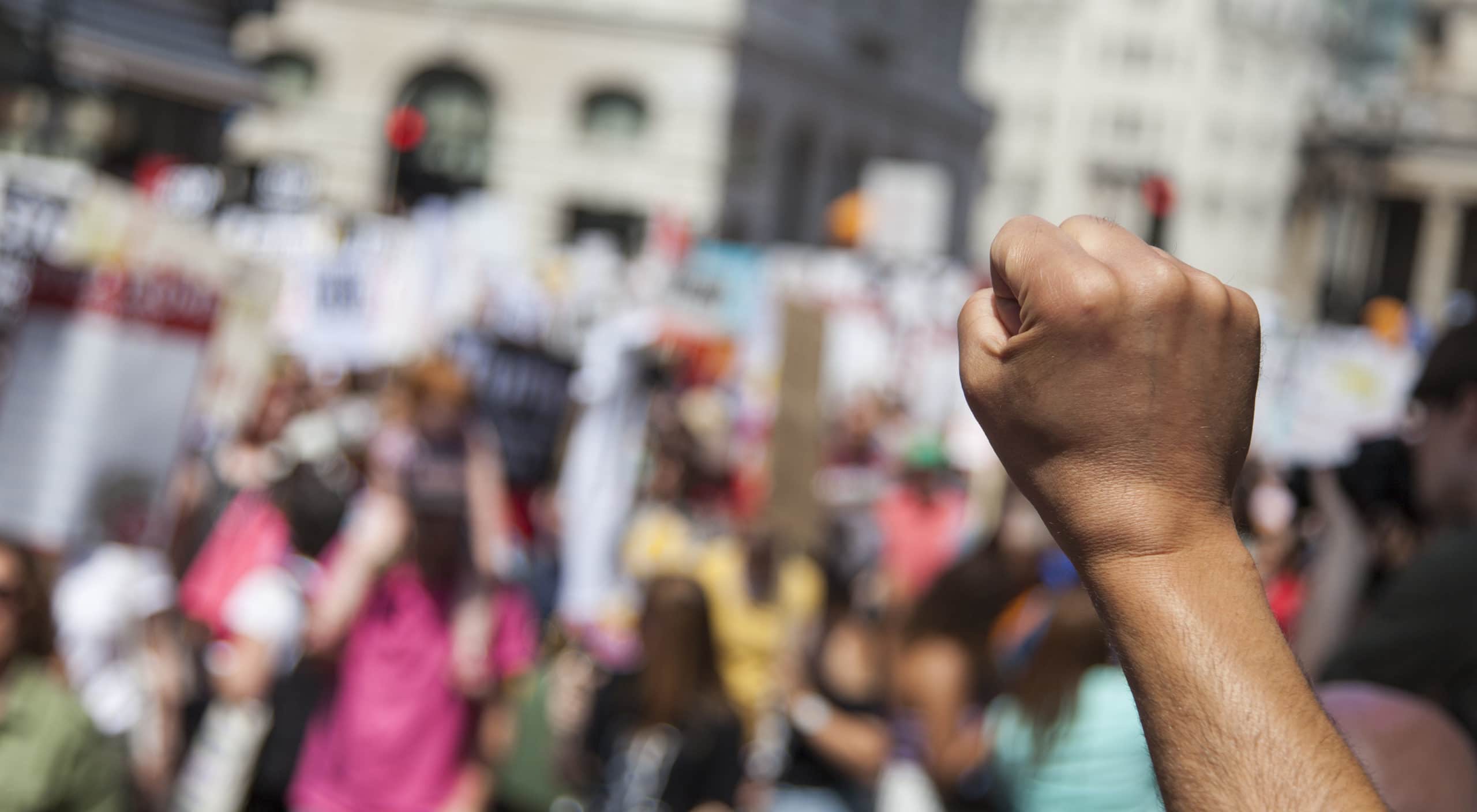 A raised fist of a protestor at a political demonstration