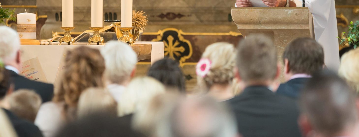 priest giving homily sermon, people listening, in church, catholic Mass