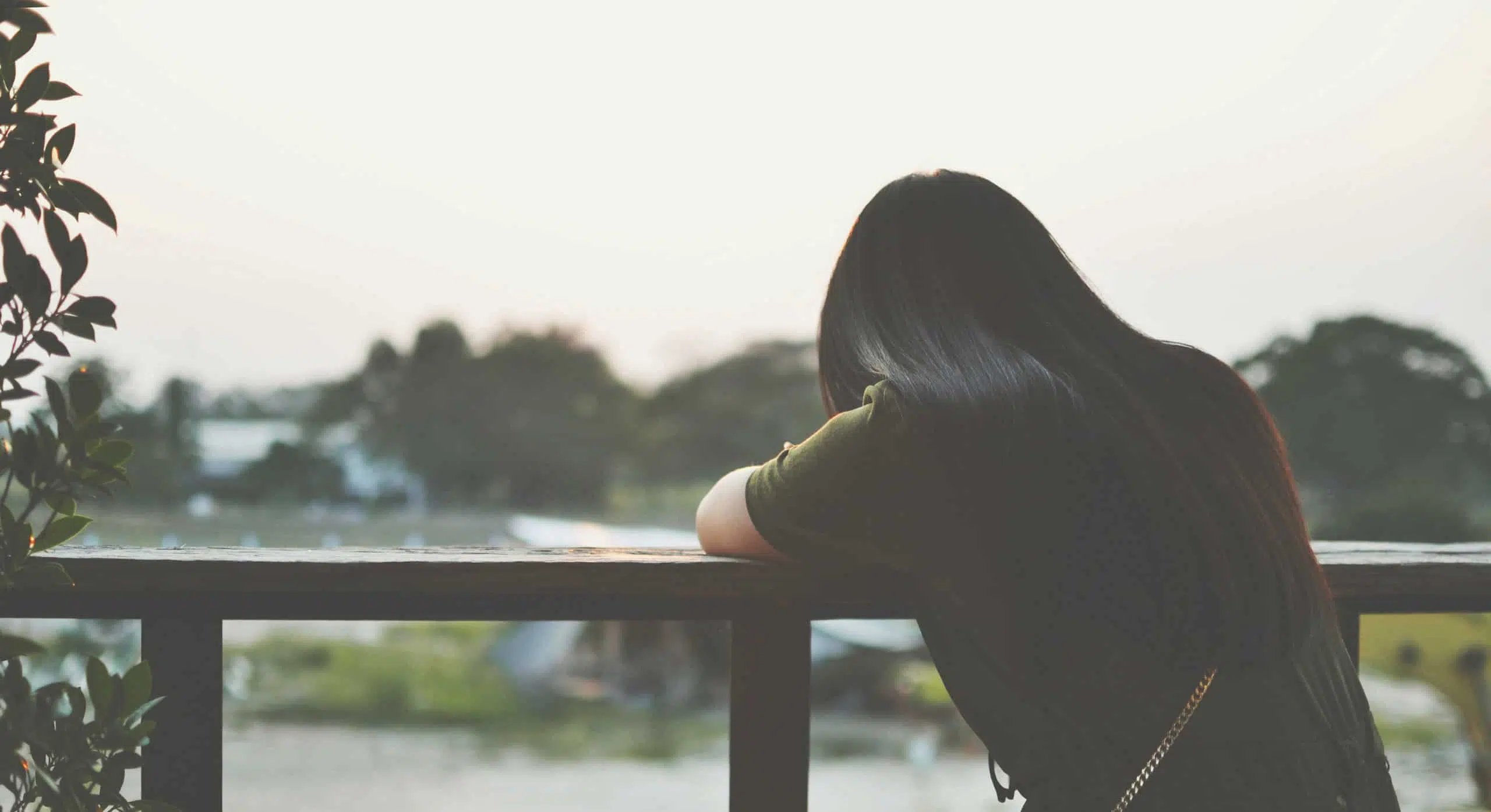 The shadow of a sad woman sitting on balcony alone
