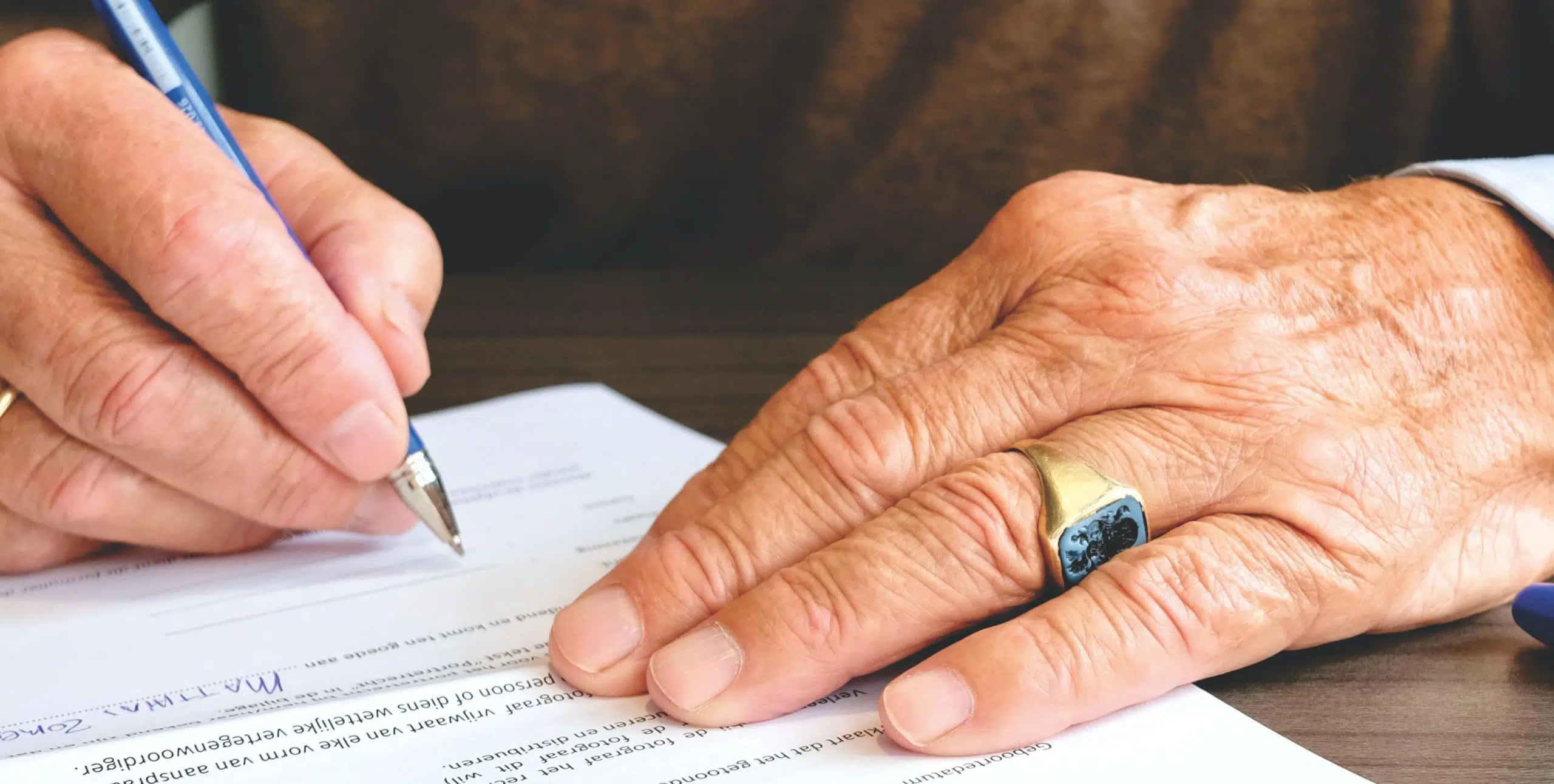 old man signing papers