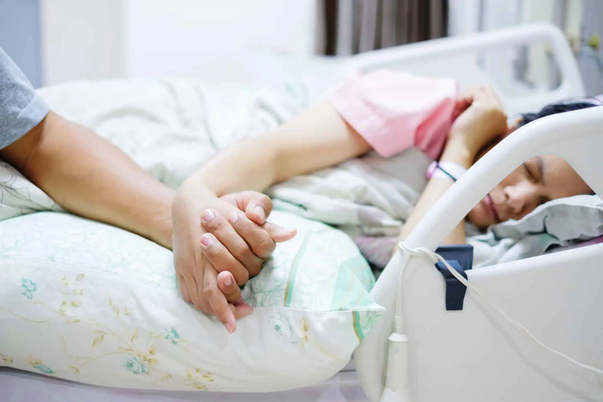 Hand of man hold hands with woman on the hospital bed