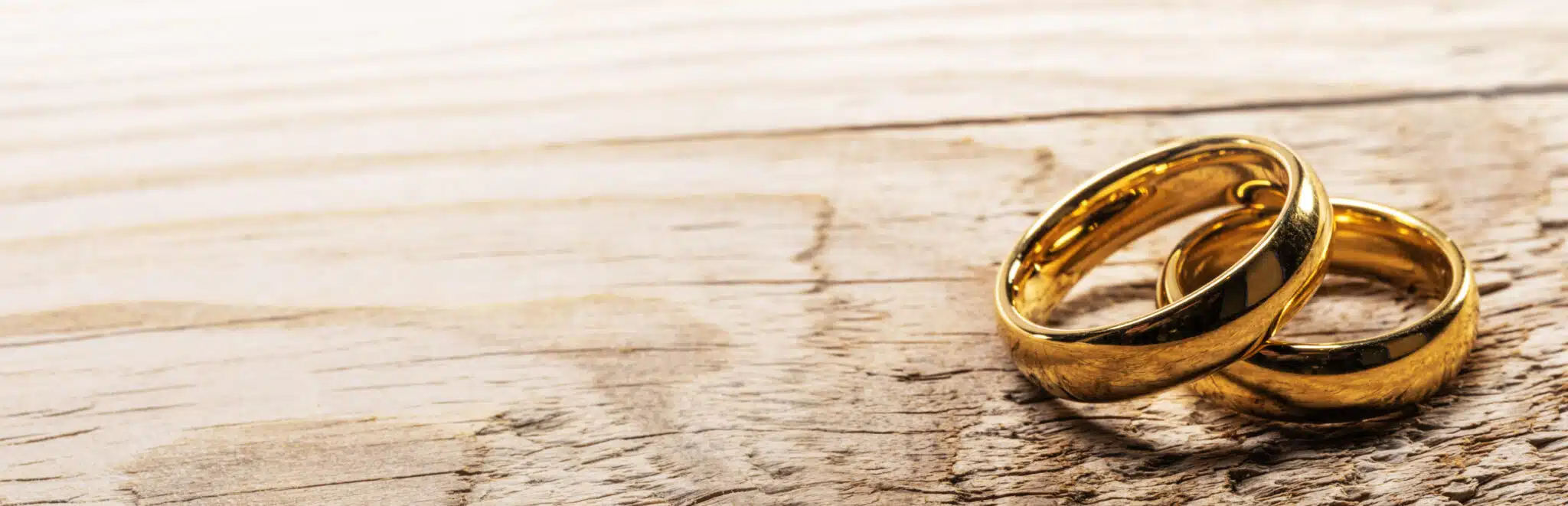 Two golden wedding rings on wooden background