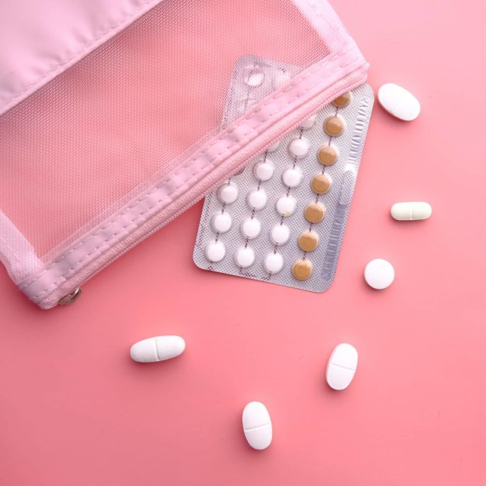 birth control pills on pink background, Top view