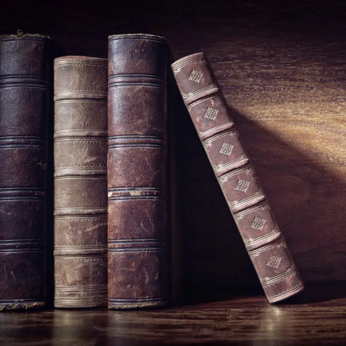 Old books on a library or bookshop shelf background