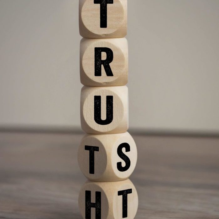 Cubes, dice or blocks with trust and truth on wooden background