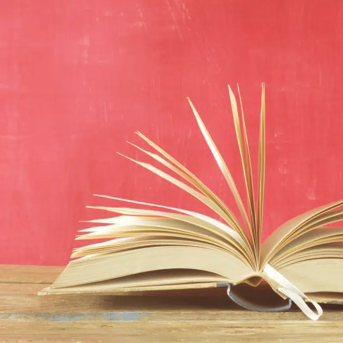 open book on table pink background