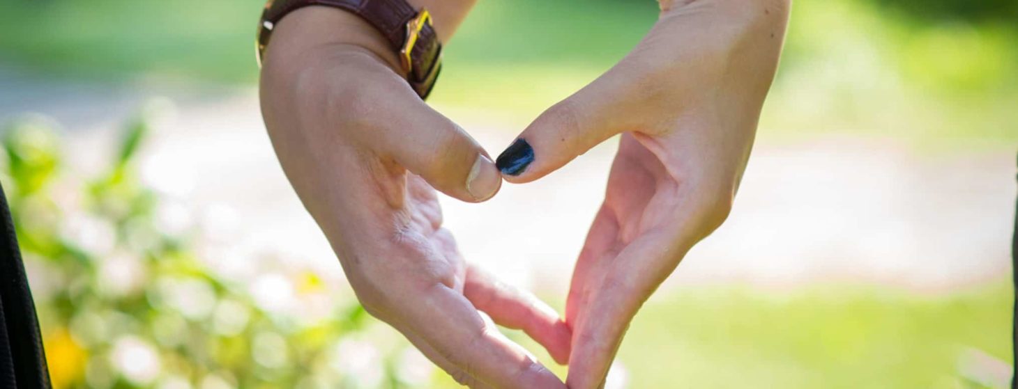 young couple's hands making a heart together