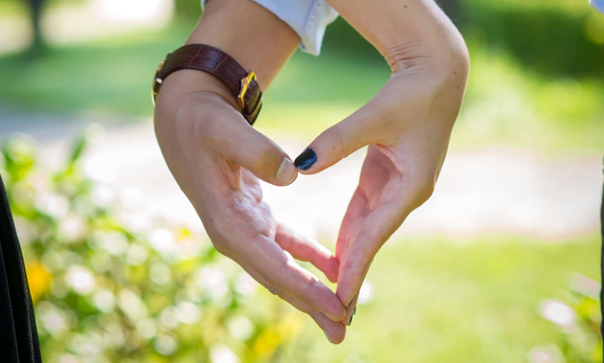 young couple's hands making a heart together