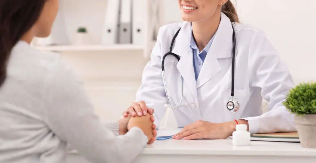 Positive Doctor Woman Comforting Unrecognizable Female Patient During Appointment In Office. Selective Focus