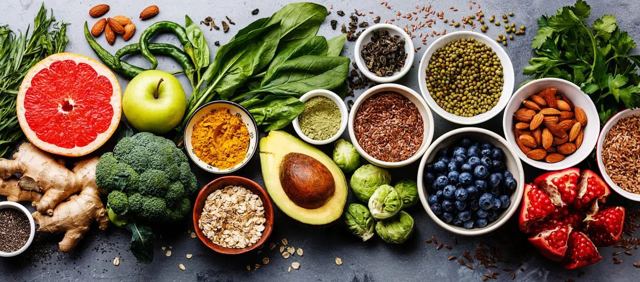 fruits, vegetables, seeds, and nuts - lots of healthy food on a table