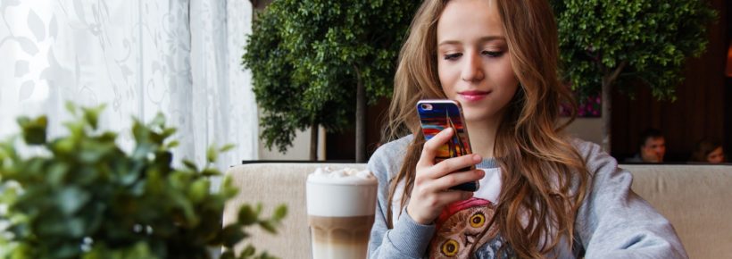 teenage girl on her phone in a coffee shop