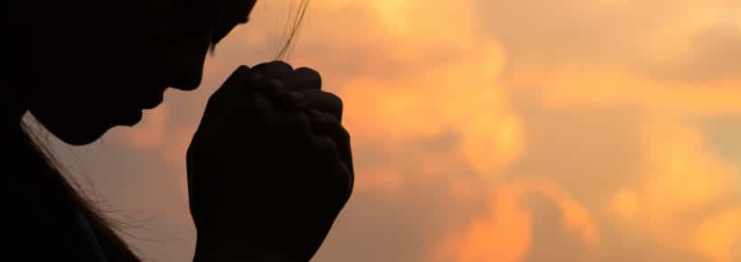 silhouette of a woman praying to God