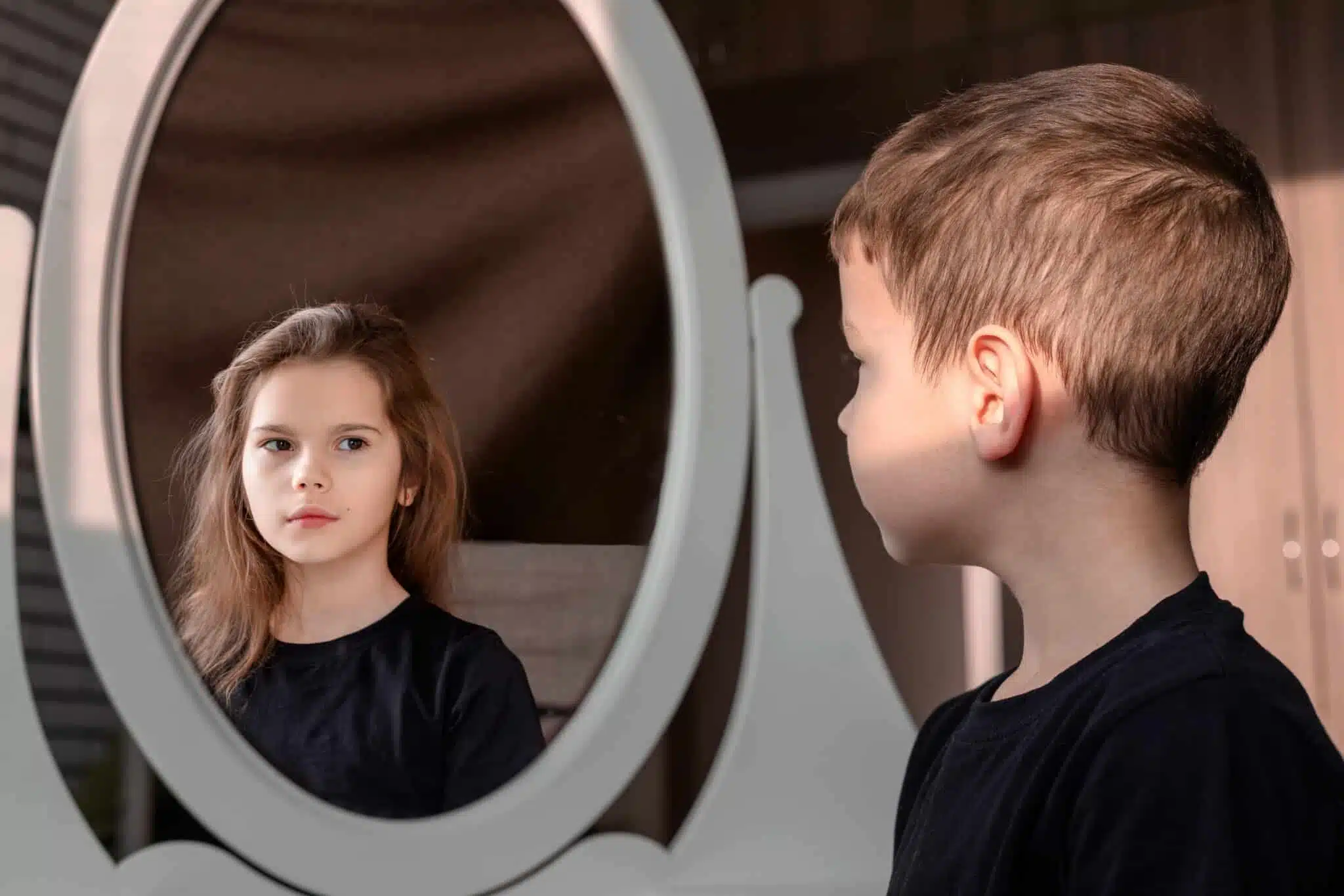 Boy with gender dysphoria looking in mirror