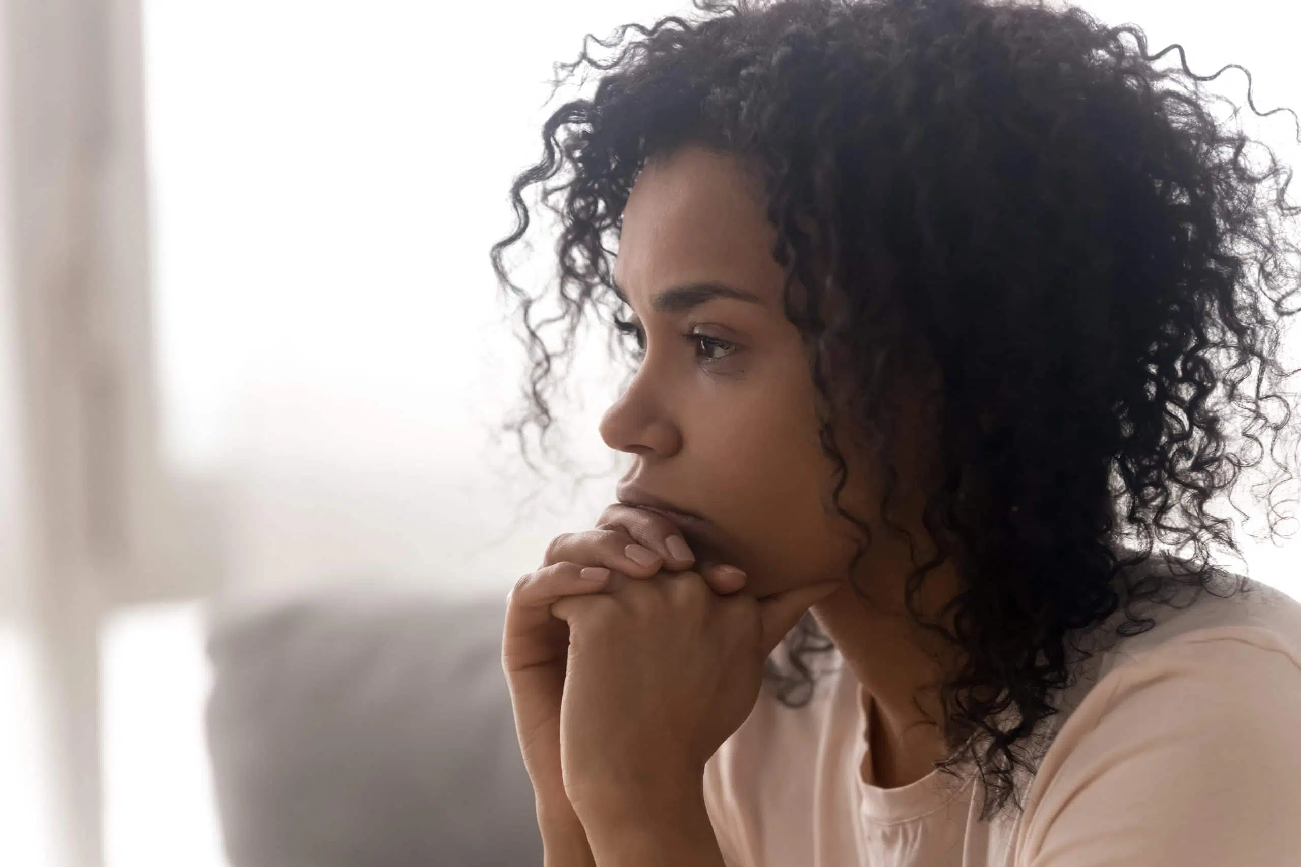 Close up side profile view of pensive young african American woman thinking of relationships problems, thoughtful black biracial female feel despair lost in thoughts consider life trouble or drama