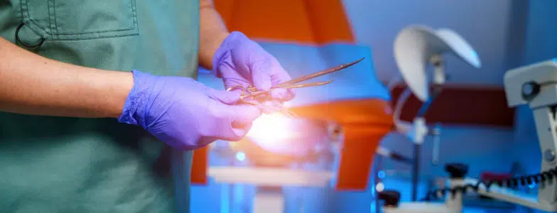 A doctor holds gynecological instruments in his hand. Examination by a gynecologist.