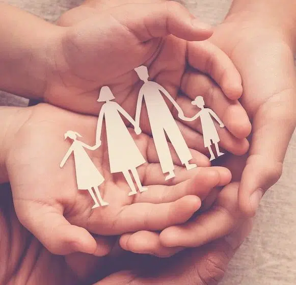 Adult and children hands holding paper family cutout