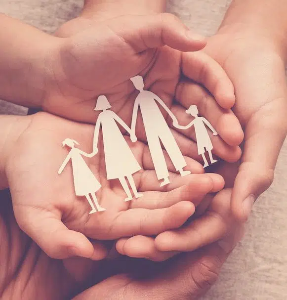 Adult and children hands holding paper family cutout