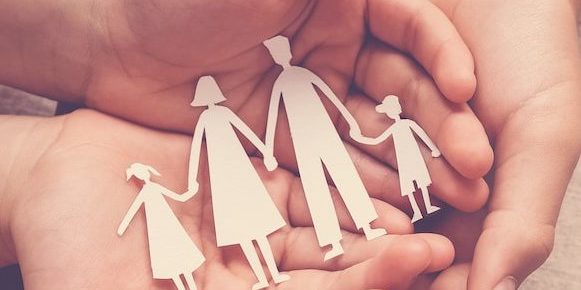 Adult and children hands holding paper family cutout