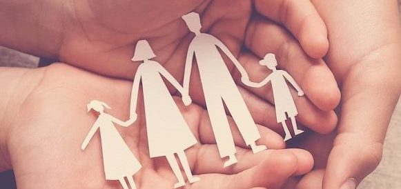 Adult and children hands holding paper family cutout