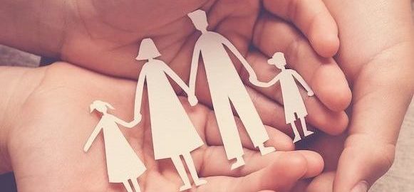 Adult and children hands holding paper family cutout