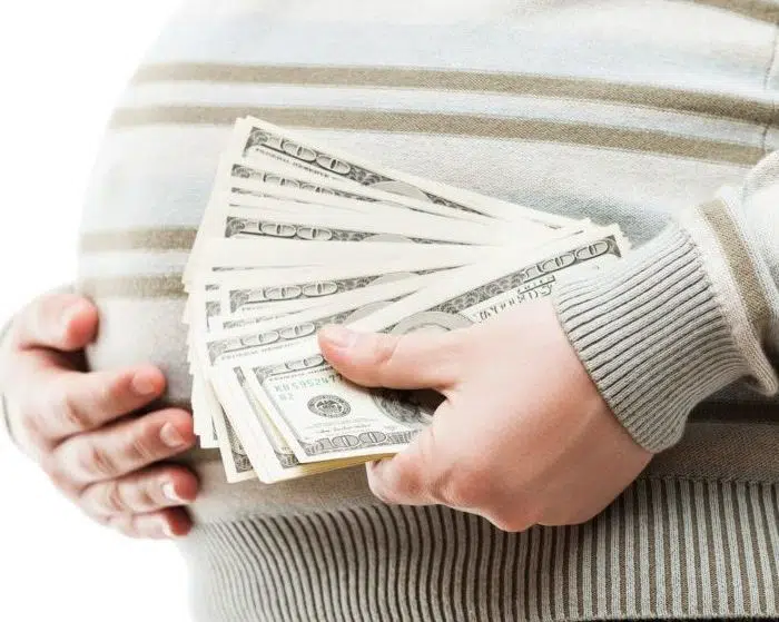 pregnant surrogate holding cash