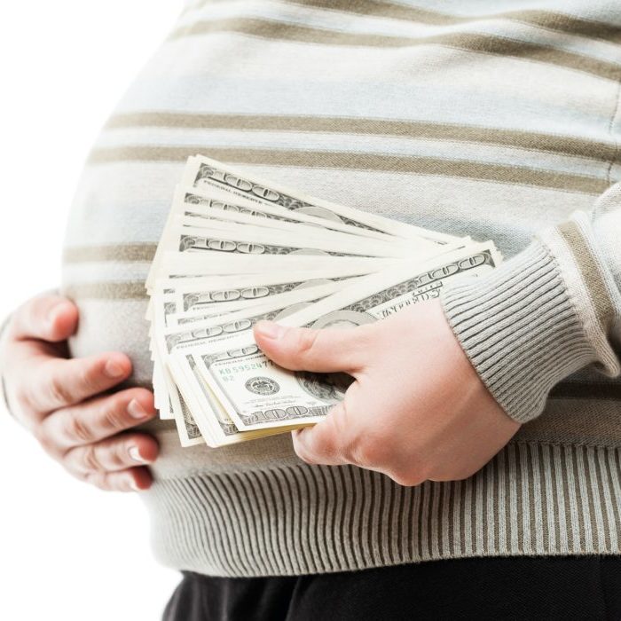 pregnant surrogate holding cash