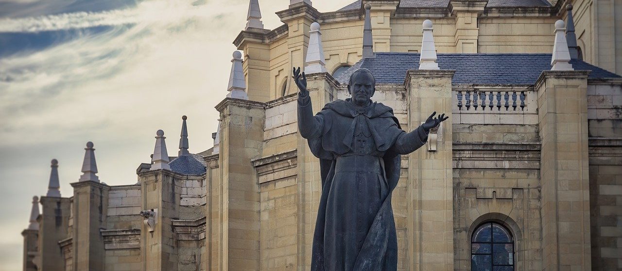 statue of john paul ii in front of a church