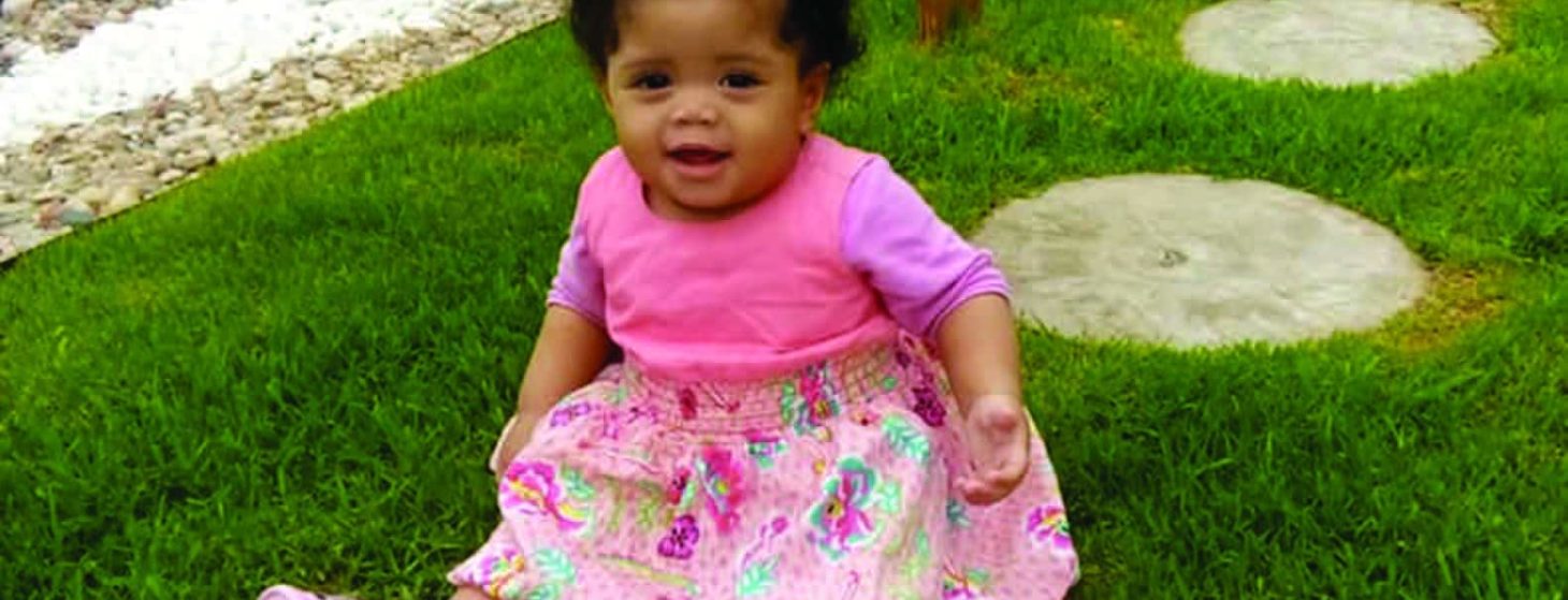 African baby girl sitting on the grass