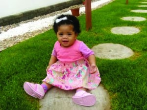 African baby girl sitting on the grass