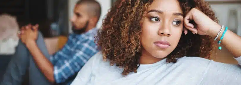 Unhappy couple and sad woman upset after argument or conflict with her man on home sofa. Angry girlfriend or female thinking about disagreement or ignoring partner, tired of relationship problems