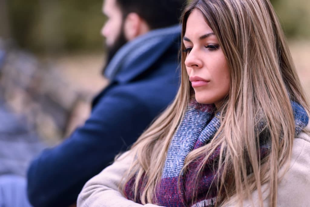Couple sitting in park having relationship problems